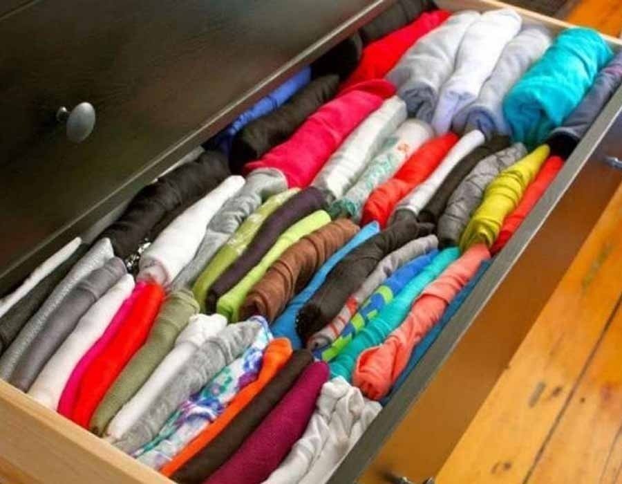 Аккуратно сложенные футболки в шкафу